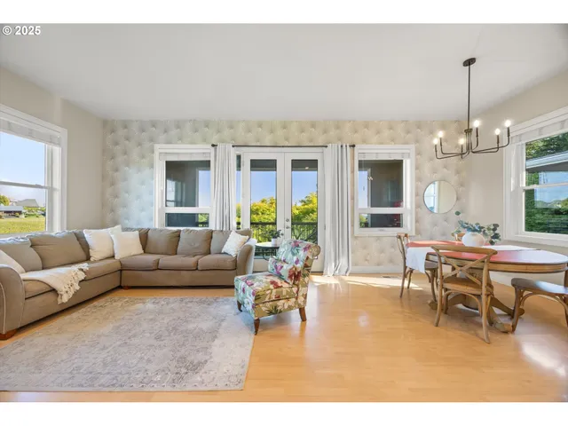 a living room with furniture a chandelier and a dining table