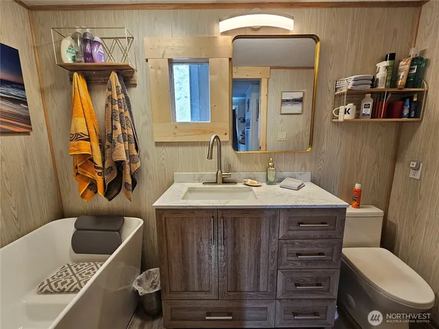 a bathroom with a double vanity sink a tub and a mirror