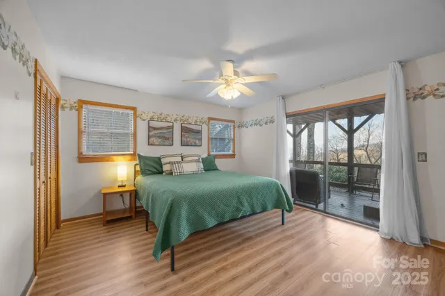 a room with a balcony a bed and a chandelier