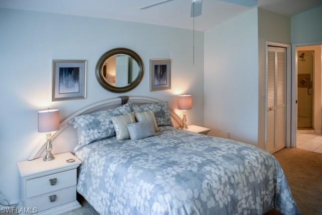 8083 Panther Trail, Unit 1504 Naples, FL 34113 - Photo 11 of 24 a bedroom with a bed and a closet with mirror