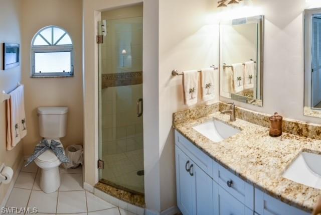 8083 Panther Trail, Unit 1504 Naples, FL 34113 - Photo 13 of 24 a bathroom with a granite countertop sink toilet and shower