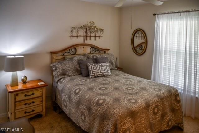 8083 Panther Trail, Unit 1504 Naples, FL 34113 - Photo 15 of 24 a bedroom with a bed and a closet with mirror