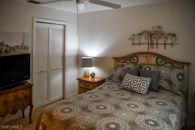 8083 Panther Trail, Unit 1504 Naples, FL 34113 - Photo 16 of 24 a bedroom with a bed and a flat tv screen on dresser