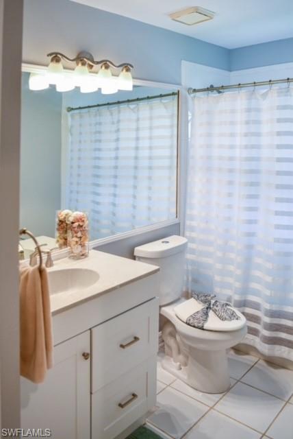 8083 Panther Trail, Unit 1504 Naples, FL 34113 - Photo 17 of 24 a bathroom with a sink a toilet and shower curtain