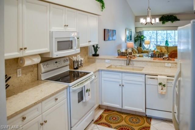 8083 Panther Trail, Unit 1504 Naples, FL 34113 - Photo 8 of 24 a kitchen with a sink stove and cabinets