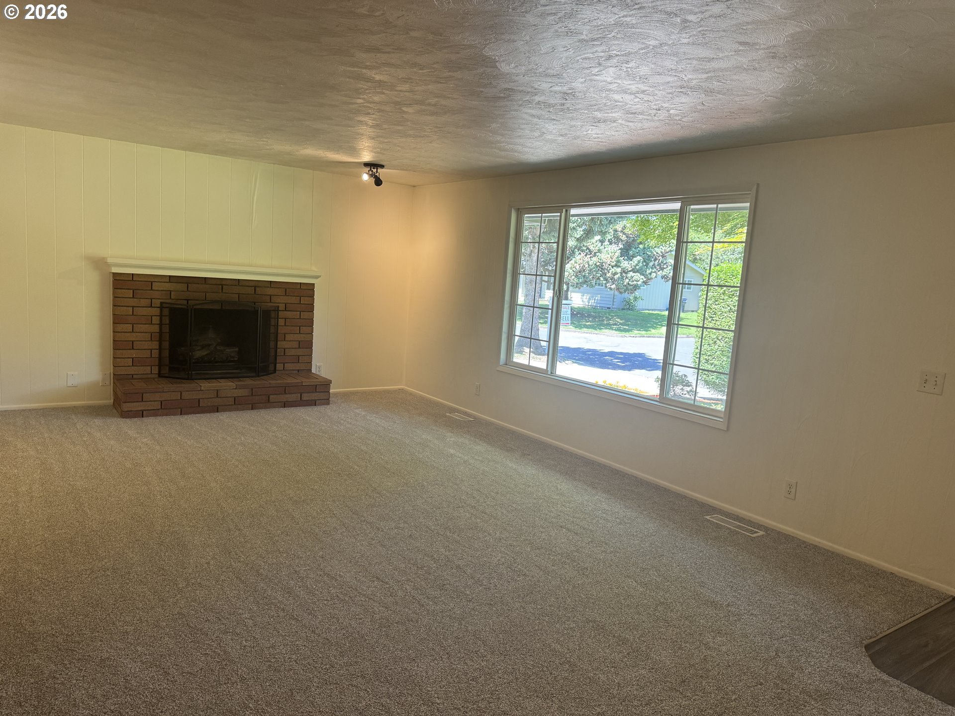 260 Susan Street Eugene, OR 97404 - Photo 5 of 33 an empty room with a fireplace and windows