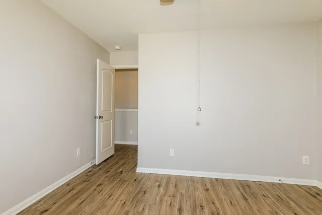 a view of an empty room with wooden floor
