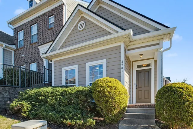 a view of a brick house with a large windows and a flower plants