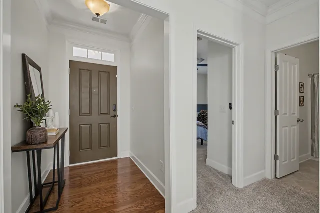 a view of a hallway with wooden floor and a livingroom