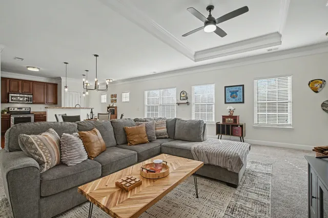 a living room with furniture kitchen view and a window
