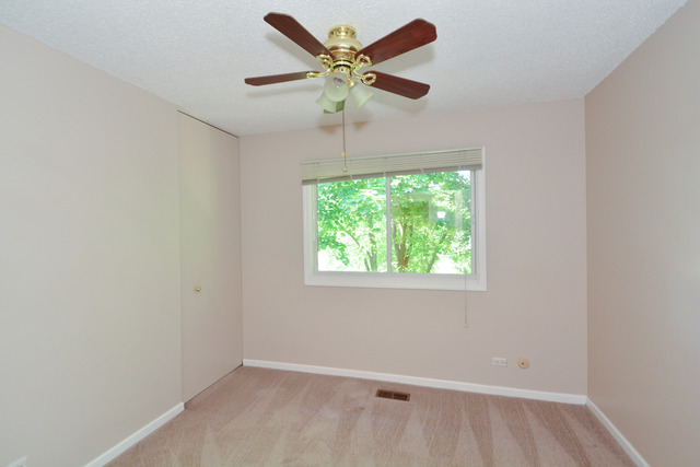 30W279 Ridgewood Court Warrenville, IL 60555 - Photo 16 of 23 an empty room with a window and a fan