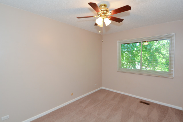 30W279 Ridgewood Court Warrenville, IL 60555 - Photo 18 of 23 an empty room with a window and a fan