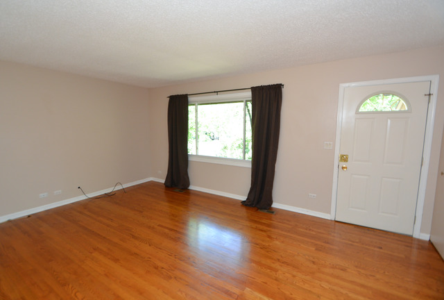 30W279 Ridgewood Court Warrenville, IL 60555 - Photo 3 of 23 an empty room with wooden floor and windows