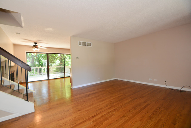 30W279 Ridgewood Court Warrenville, IL 60555 - Photo 4 of 23 a view of an empty room with wooden floor and a window