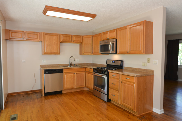 30W279 Ridgewood Court Warrenville, IL 60555 - Photo 5 of 23 a kitchen with granite countertop a sink cabinets and stainless steel appliances