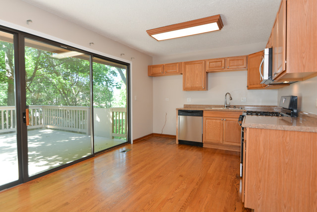 30W279 Ridgewood Court Warrenville, IL 60555 - Photo 7 of 23 a kitchen with stainless steel appliances granite countertop a stove a sink and a microwave
