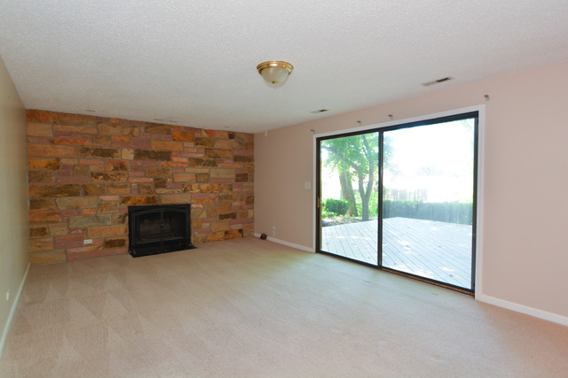 30W279 Ridgewood Court Warrenville, IL 60555 - Photo 9 of 23 a view of an empty room with a fireplace and a window