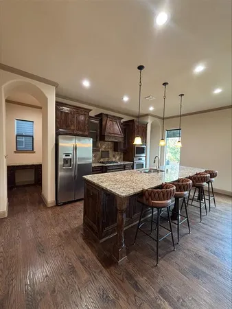 a kitchen with kitchen island a dining table chairs and wooden floor