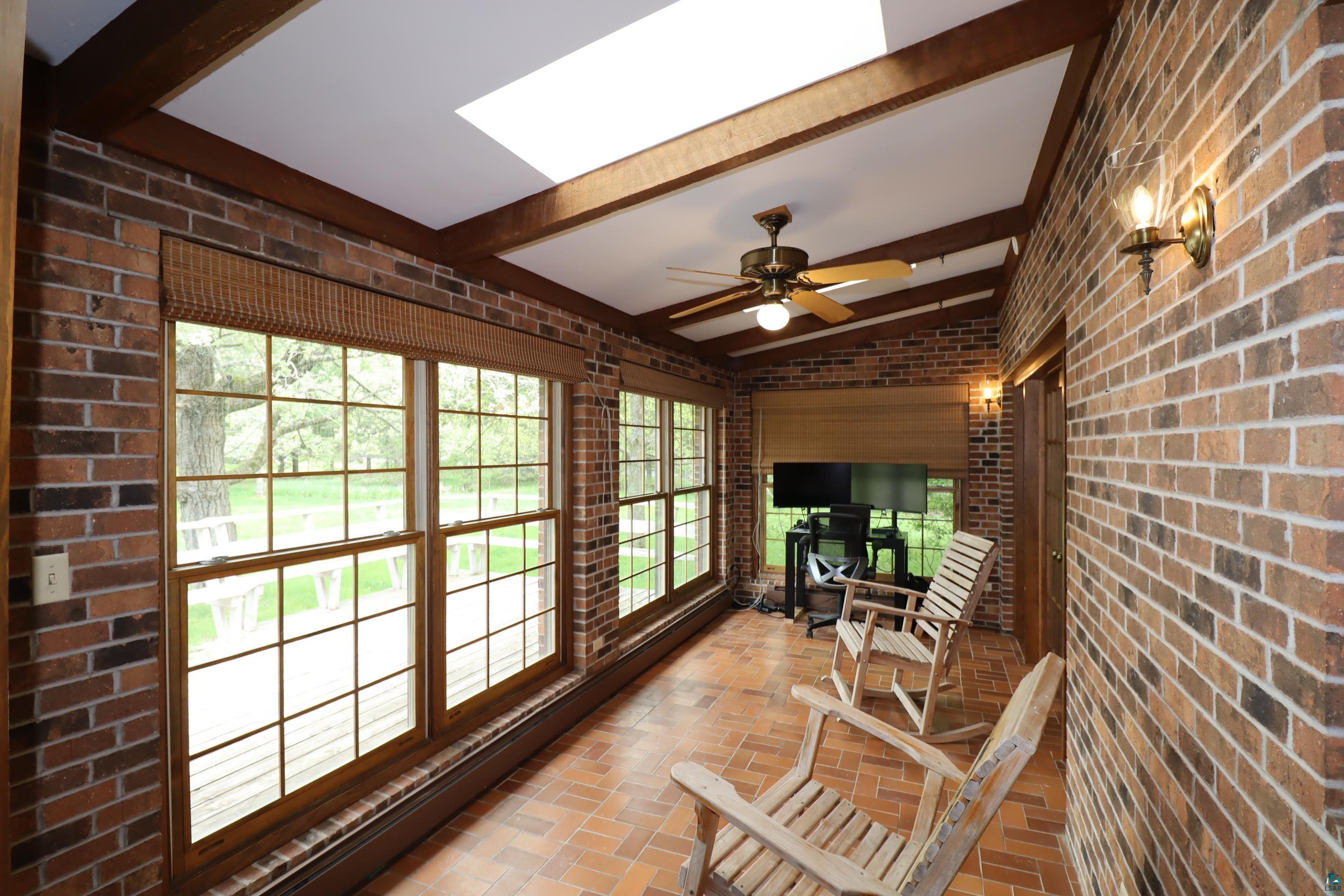 200 Maple Ridge Ashland, WI 54806 - Photo 13 of 40 Sunroom with plenty of natural light, beam ceiling, and ceiling fan