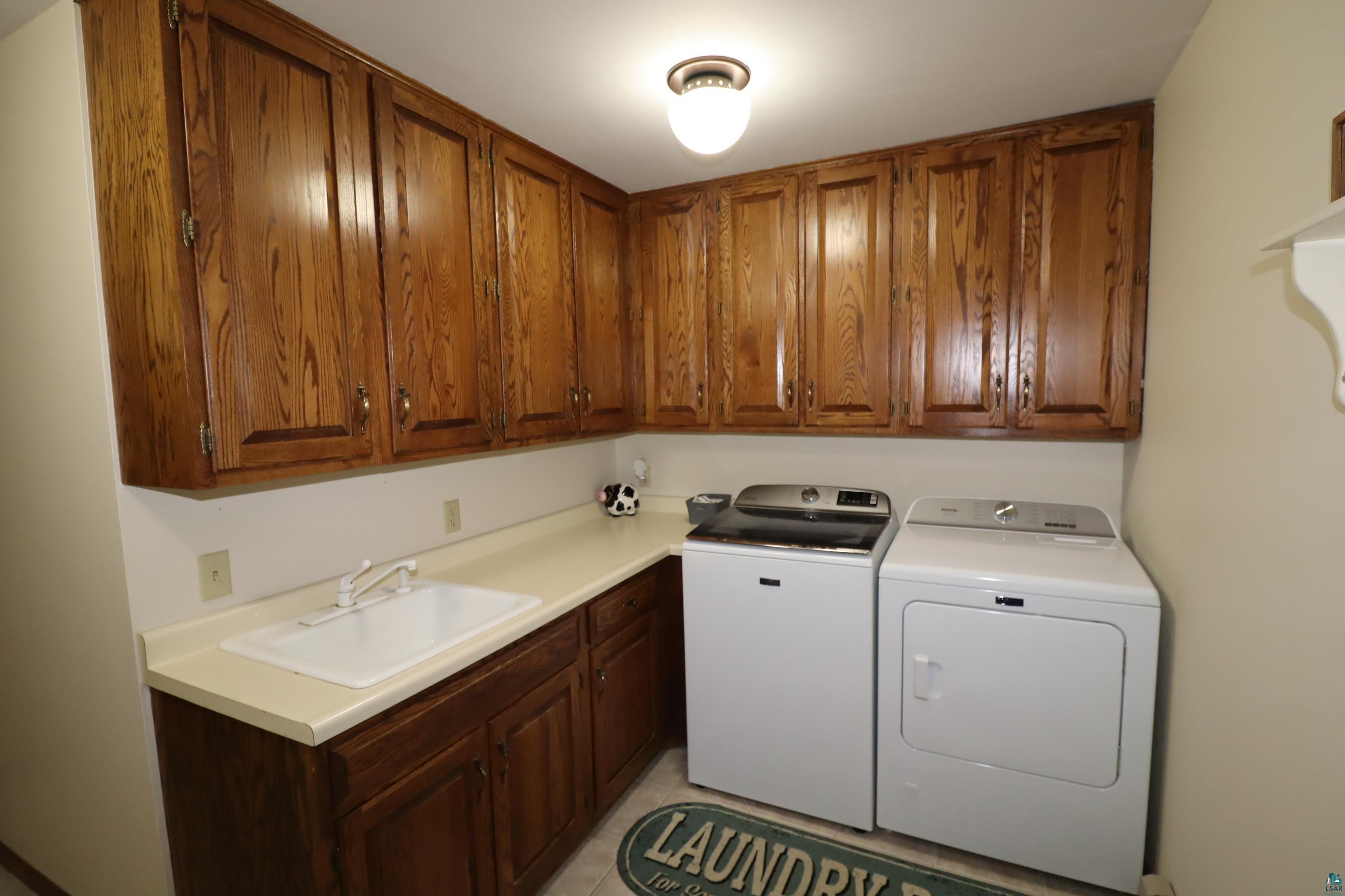 200 Maple Ridge Ashland, WI 54806 - Photo 31 of 40 Laundry room with washer and clothes dryer, sink, and cabinets