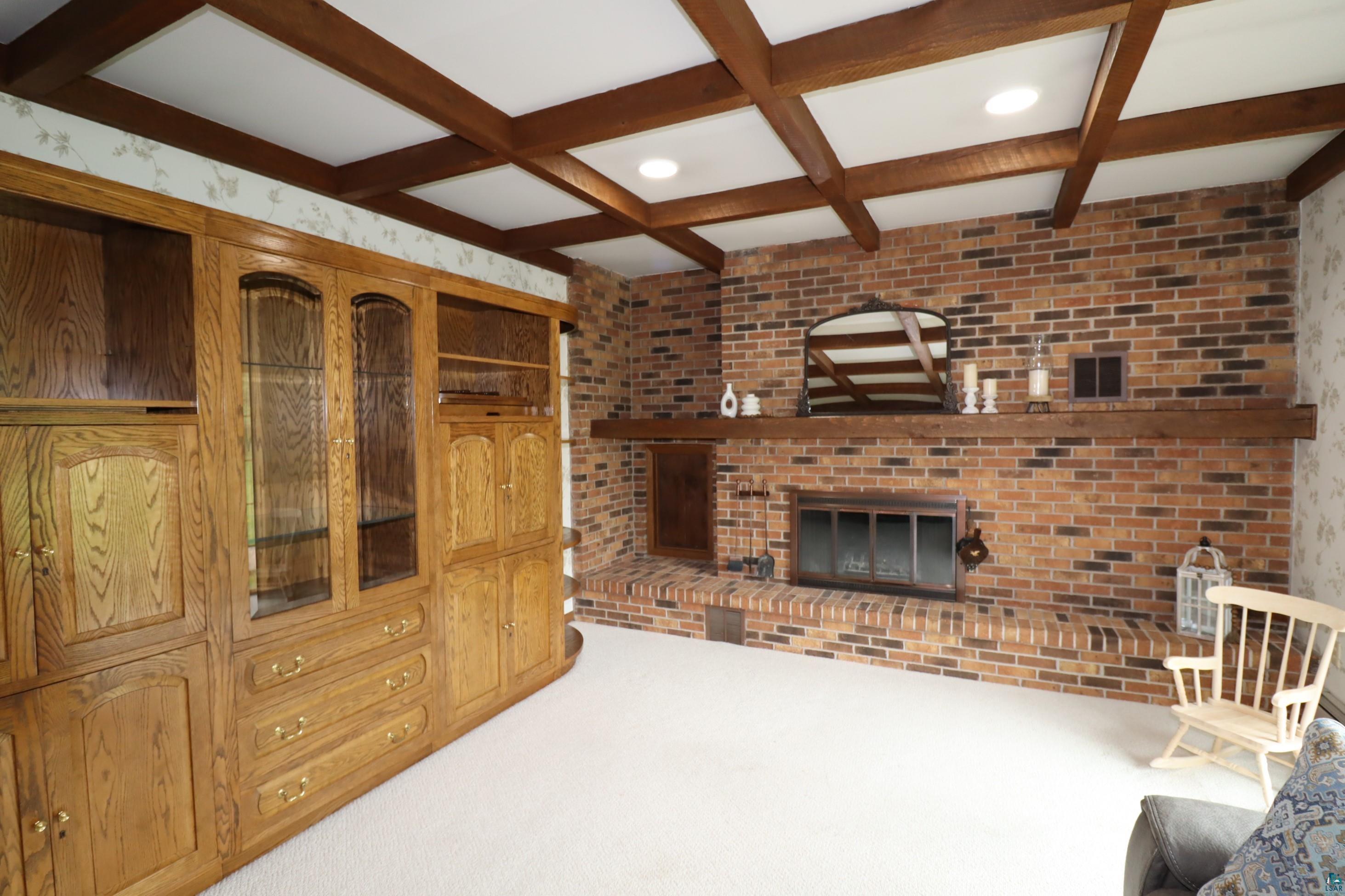 200 Maple Ridge Ashland, WI 54806 - Photo 7 of 40 Family room with carpet flooring, a brick fireplace, beamed ceiling, and coffered ceiling.