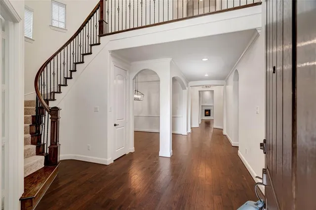 a view of a hallway with wooden floor and staircase