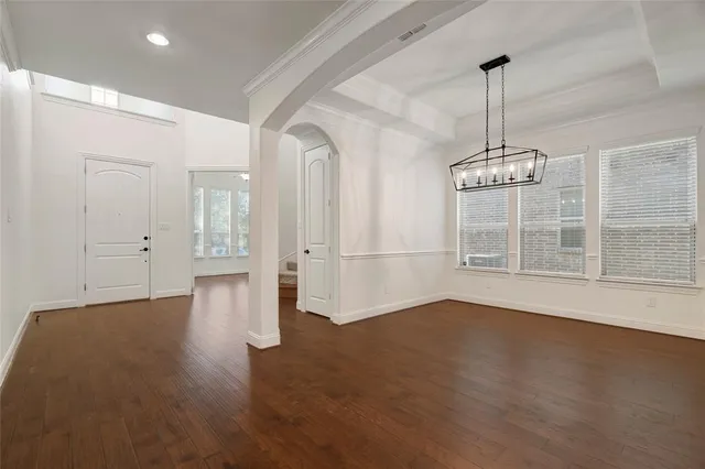 a view of empty room with wooden floor and window