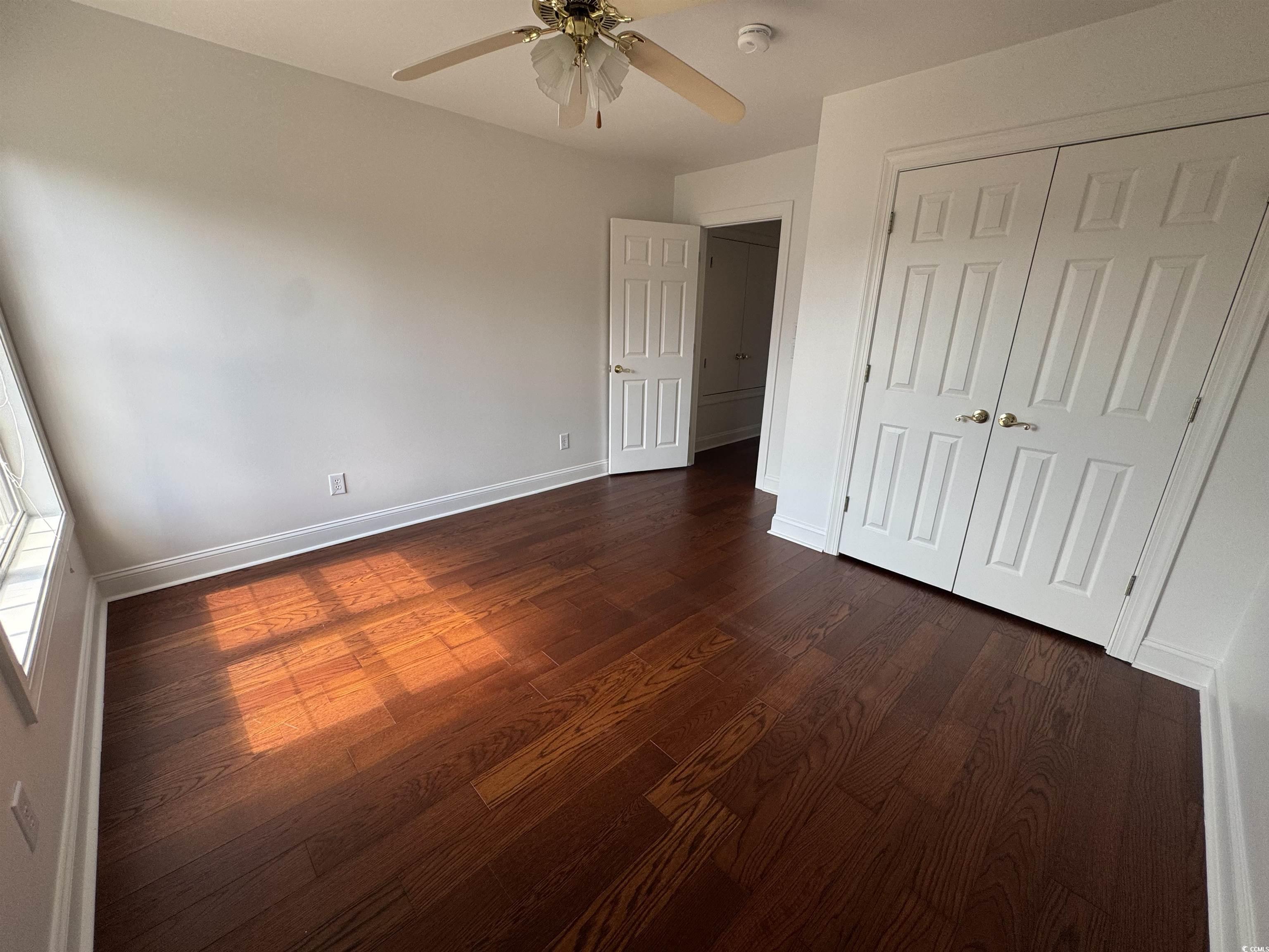 3848 Waterford Drive Myrtle Beach, SC 29577 - Photo 11 of 12 Unfurnished bedroom with dark wood-type flooring, ceiling fan, and a closet