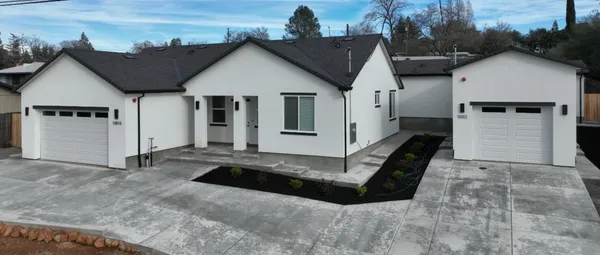a view of a big house with wooden fence