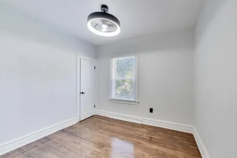 a view of empty room with window and ceiling fan