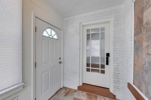 an empty room with wooden floor cabinet and windows