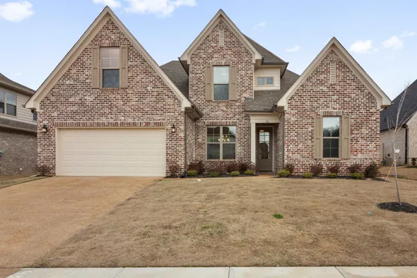 a front view of a house with a yard and garage