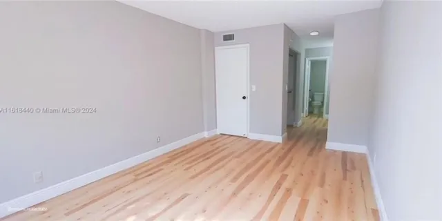 a view of a room with wooden floor and bench
