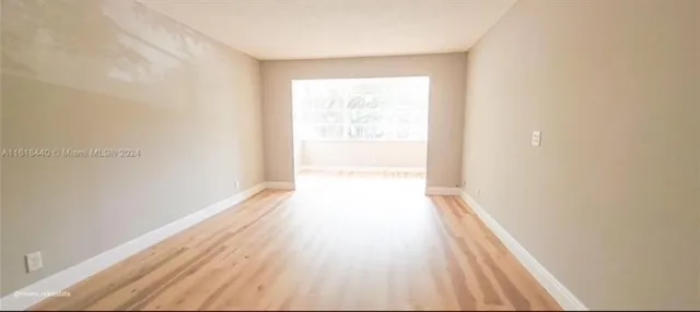 a view of a room with wooden floor and a window