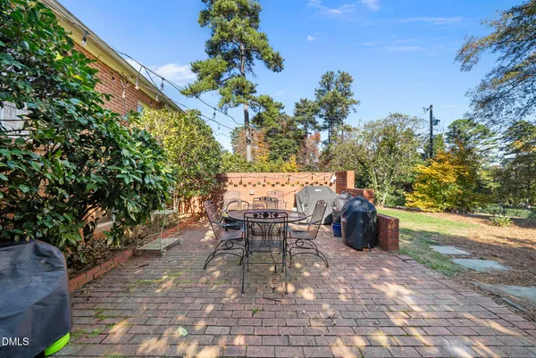 a roof deck with table and chairs and potted plants