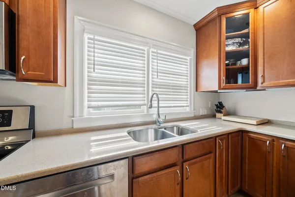 a kitchen with a refrigerator a stove a sink dishwasher with a dining table and chairs