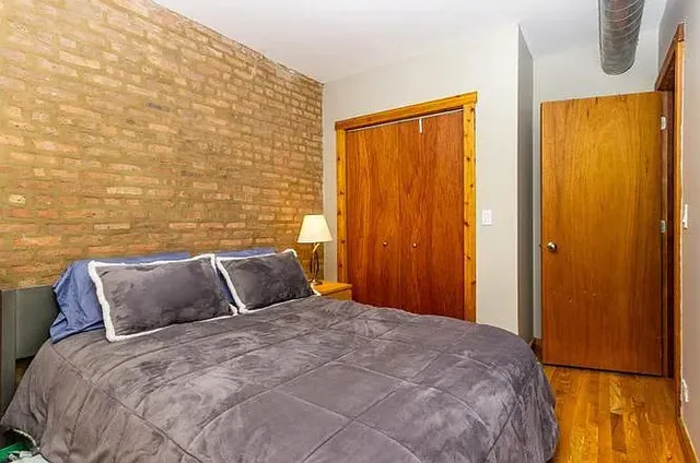 a bedroom with a bed and wooden floor