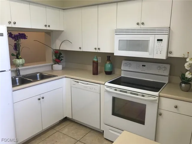 a kitchen with white cabinets and white appliances