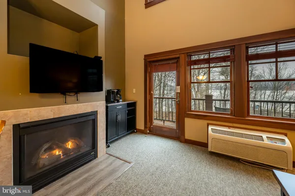 a living room with a fireplace and a flat screen tv