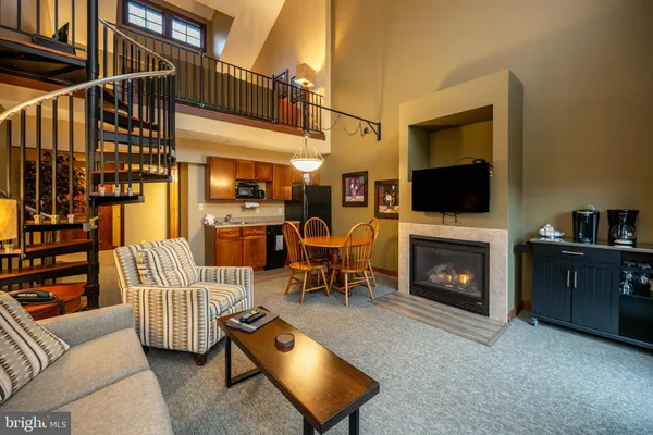 a living room with furniture a flat screen tv and a fireplace