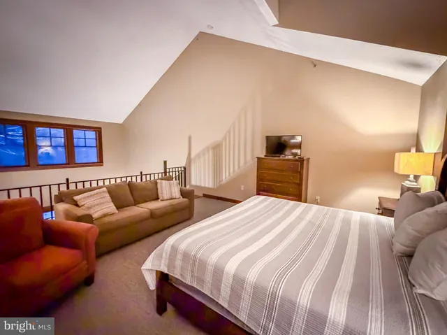 a bedroom with a bed couch and a window