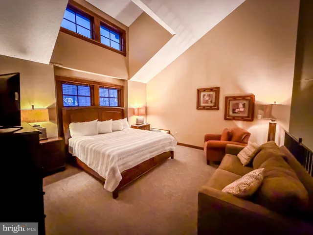 a spacious bedroom with a bed and couch