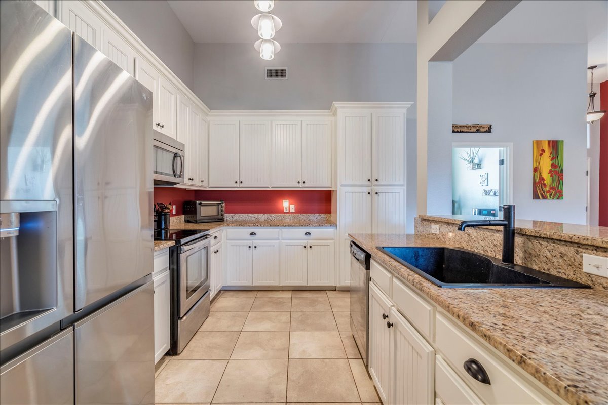 11 Rhapsody Lane Wimberley, TX 78676 - Photo 9 of 35 a kitchen with granite countertop a sink and white cabinets