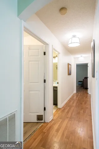 a view of a room with wooden floor and a bathroom