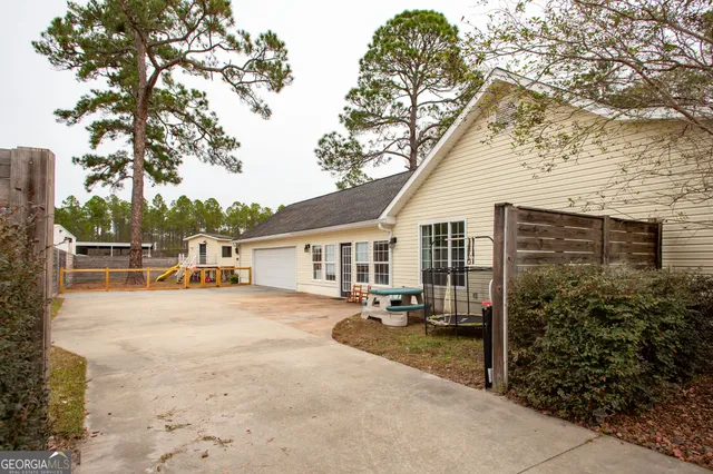 a view of a house with backyard and tree