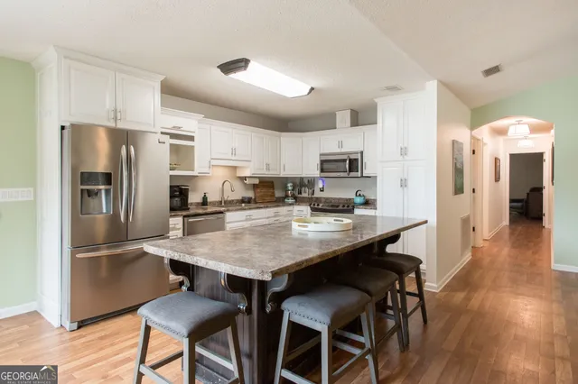 a kitchen with stainless steel appliances a refrigerator and a stove top oven