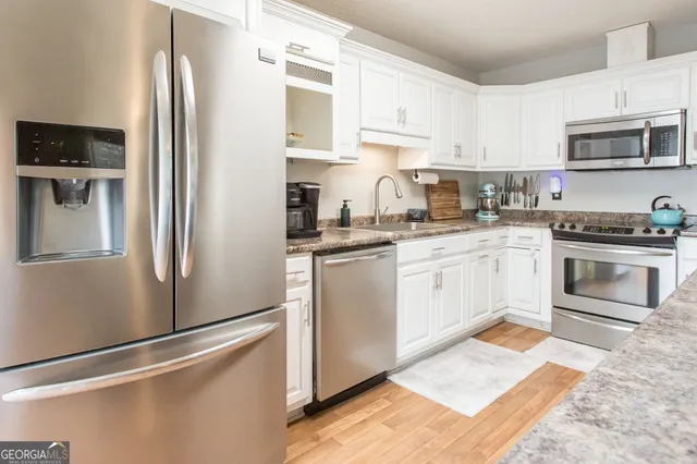 a kitchen with stainless steel appliances granite countertop a refrigerator stove a sink and dishwasher