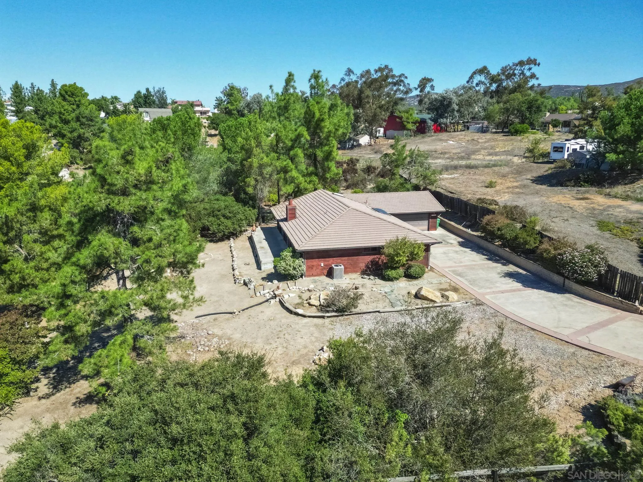 2596 Valetta Lane Alpine, CA 91901 - Photo 40 of 48 a backyard of a house with table and chairs under an umbrella