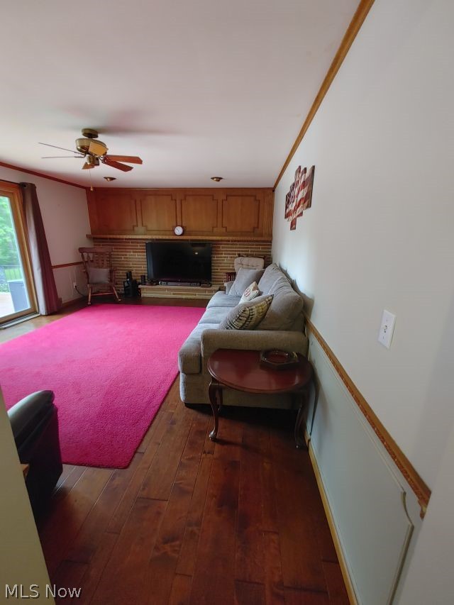 2211 Devonshire Road Northwest Canton, OH 44708 - Photo 12 of 36 Family room with ornamental molding, dark hardwood / wood-style floors, ceiling fan, and a fireplace