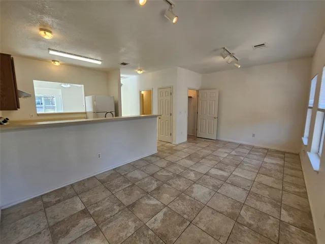 an empty room with a ceiling fan and a window